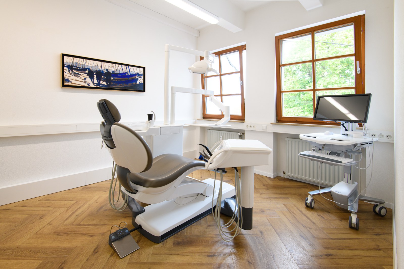 Behandlungszimmer mit modernem Behandlungsstuhl und viel Tageslicht